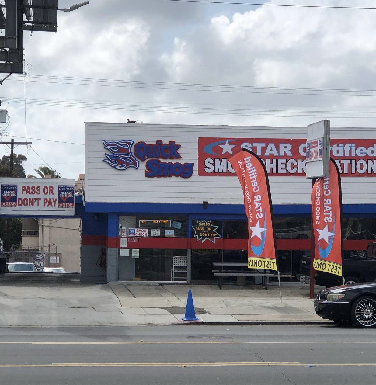 Quick Smog storefront from across Garnet Ave with STAR Certified flags